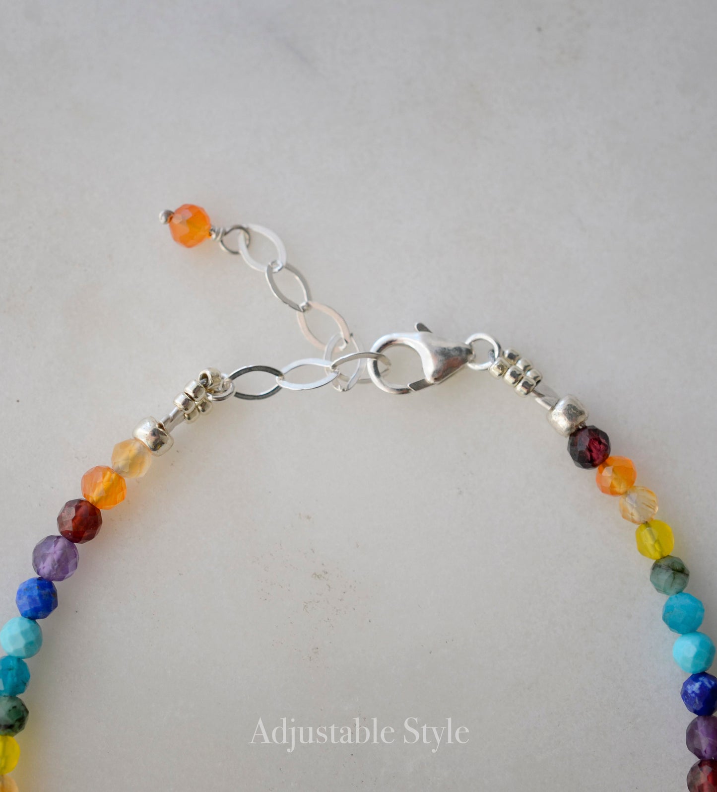Close up image of the adjustable style in sterling silver.
Tiny gemstone beaded bracelet in rainbow colors. Colors include: blue, green, yellow, red, orange, and purple.