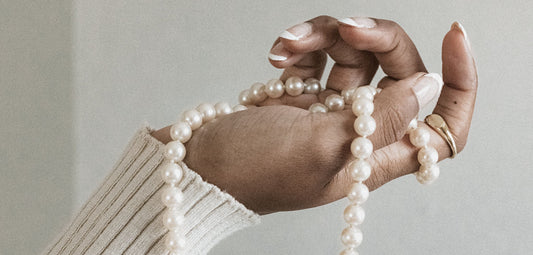 All About Pearls - Modeled image of single white pearl on gold chain.