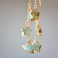 Close up of blue-green natural amazonite star shaped stones set on long dangles in gold.