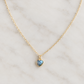 A delicate 14k gold filled chain necklace with a small heart-shaped pendant featuring a shimmering blue-gray natural labradorite gemstone. Handmade minimalist stone jewelry by Gemnia.