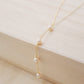 Four semi-round white freshwater pearls are suspended in a Y-style necklace on a 14k gold filled chain. Each pearl is approximately one inch apart. This necklace is also available in sterling silver.