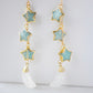 blue amazonite star earrings in gold with rainbow moonstone crescents. Each earring has three gemstone stars and one moon dangling from it.