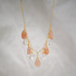 Orange, peach moonstone and clear Crystal Quartz teardrops dangle off a 14k gold filled chain. 