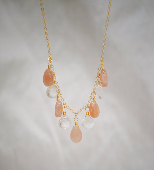 Orange, peach moonstone and clear Crystal Quartz teardrops dangle off a 14k gold filled chain. 