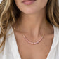 A modeled image of a beaded pink rhodochrosite necklace in 14k gold filled. The stones are natural and faceted and vary in shades of pink, including white and gray. Handmade in Connecticut by Gemnia.