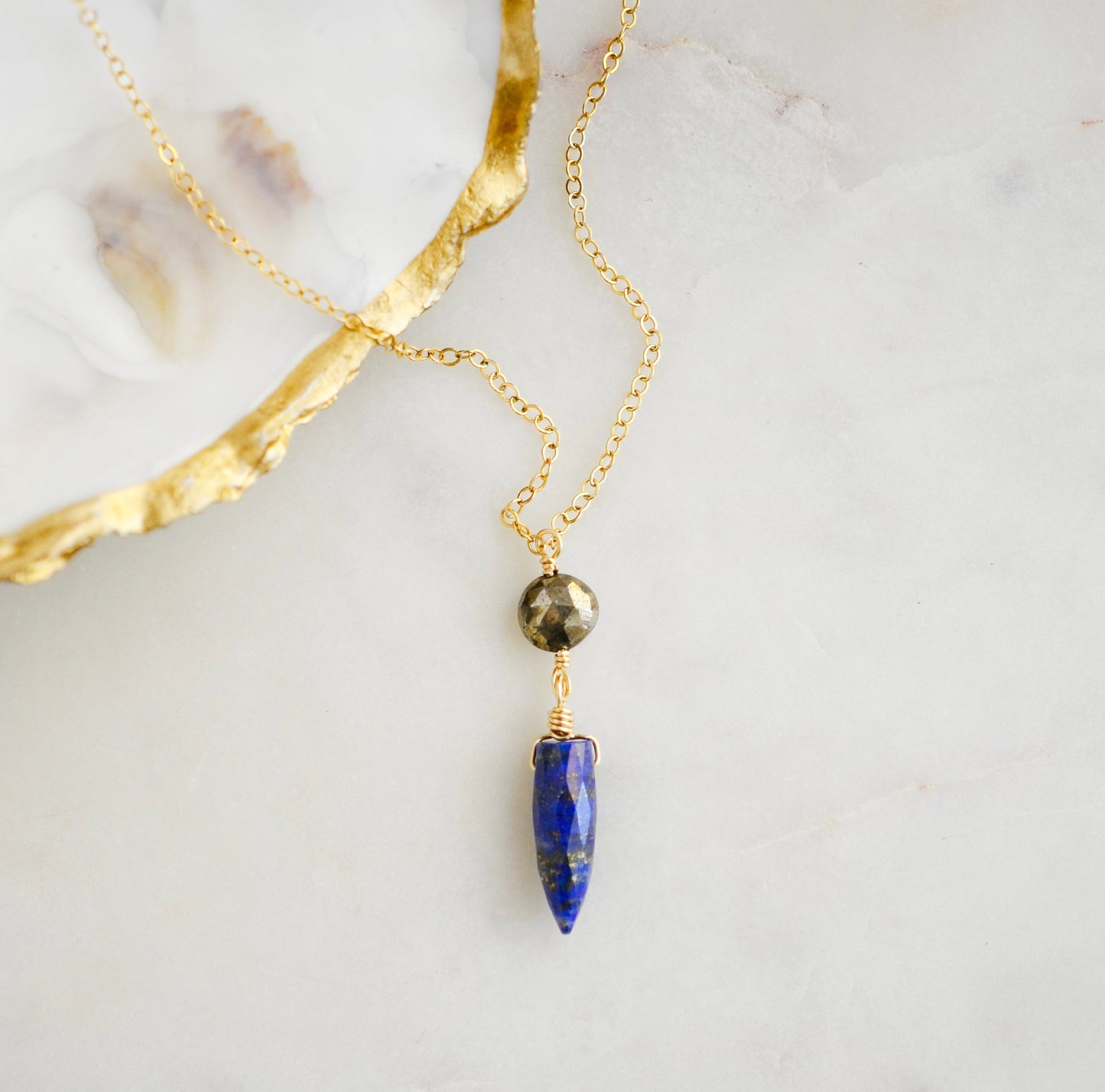 This necklace is handmade with natural pyrite and lapis lazuli suspended from a 14k gold filled or sterling silver chain.