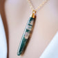 Long green, white, and clear real natural moss agate stone set on a 14k gold filled chain. The pendant is a long thin oval shape. Close Up.