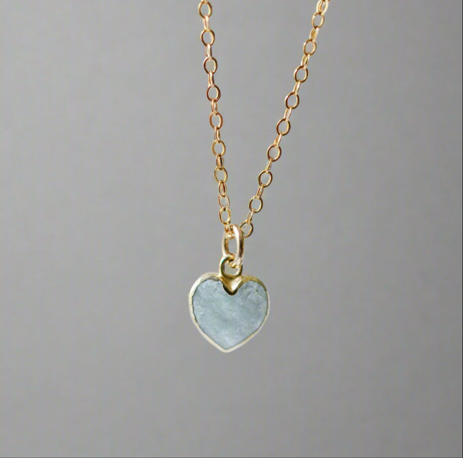 Pale blue natural aquamarine gemstone heart pendant set on a 14k gold filled chain. The stone is genuine and faceted with a 22k gold electroplate bezel.