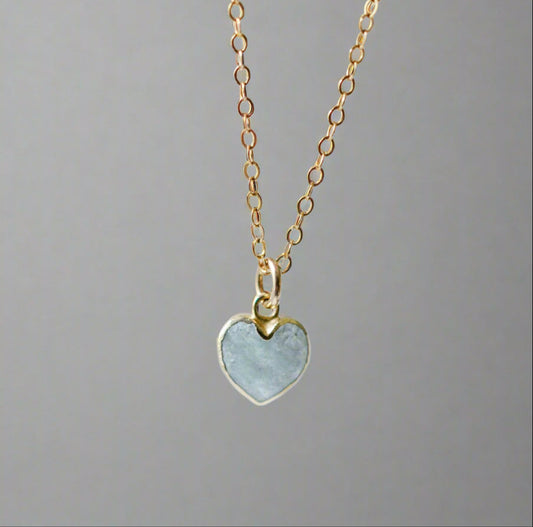 Pale blue natural aquamarine gemstone heart pendant set on a 14k gold filled chain. The stone is genuine and faceted with a 22k gold electroplate bezel.
