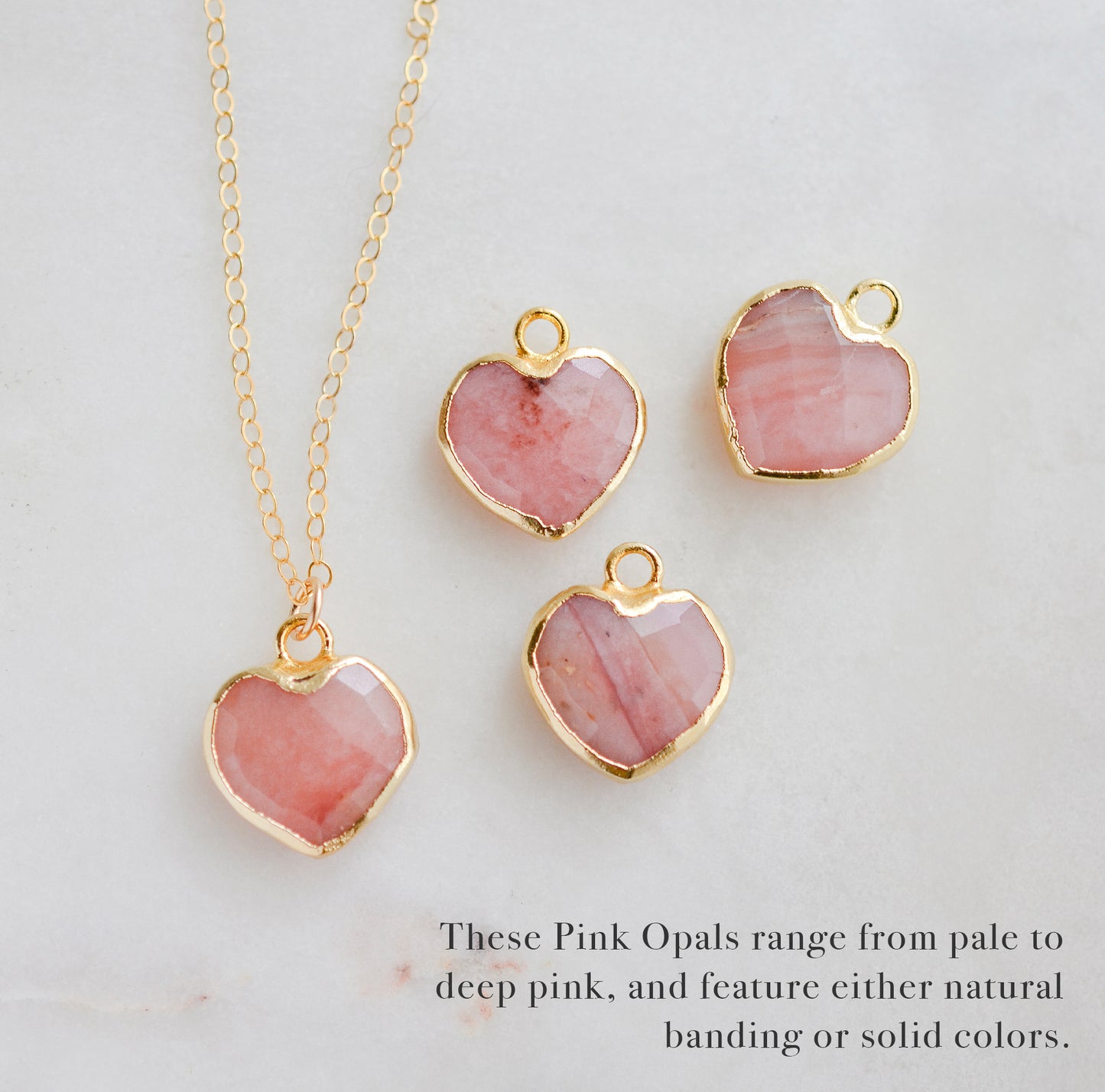 Showing the multiple colors that natural pink opal comes in. 
Handmade necklace with a natural pink opal heart-shaped pendant on a 14k gold filled chain. Handcrafted dainty gemstone jewelry by Gemnia.