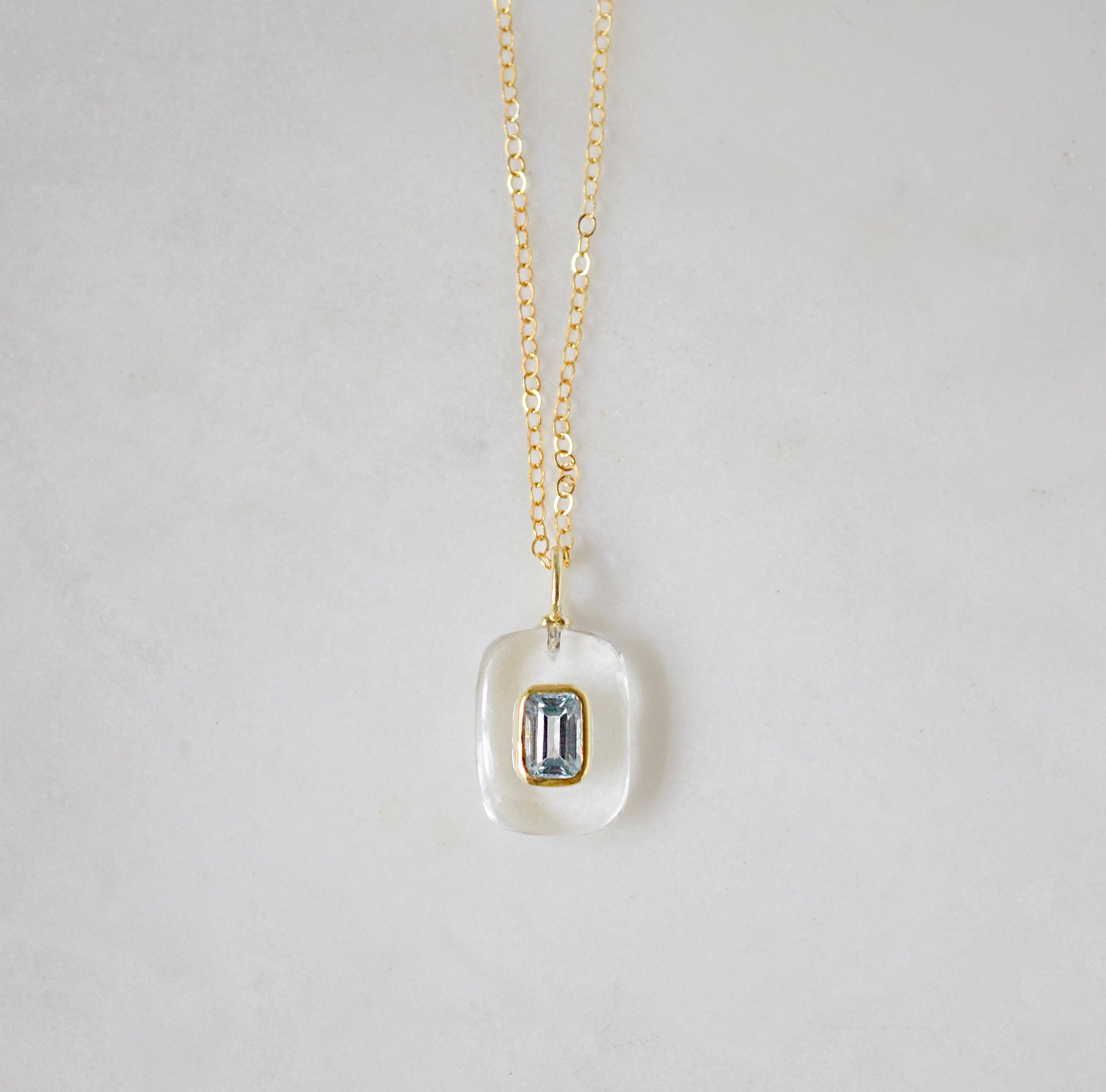 Handmade Maris necklace featuring a Blue Topaz set inside a clear Rock Crystal frame on a 14K Gold Filled chain. Ideal gift for wife, girlfriend, or mom. Minimalist topaz pendant for layering.