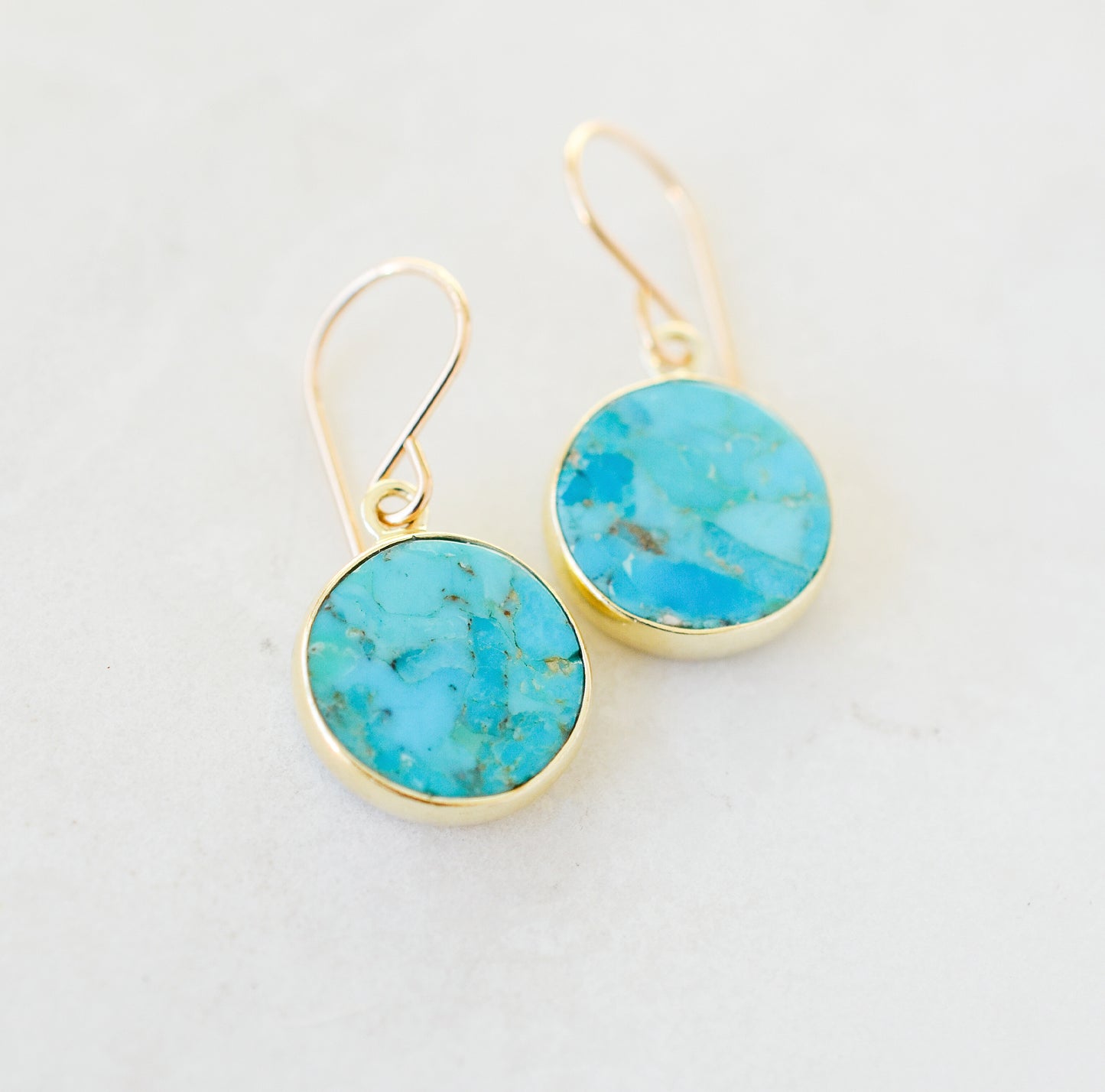 Handmade real Turquoise dangle earrings with gold hooks. The stone is smooth polished and set in vermeil bezels. Also available in sterling silver. Handcrafted in Connecticut.
