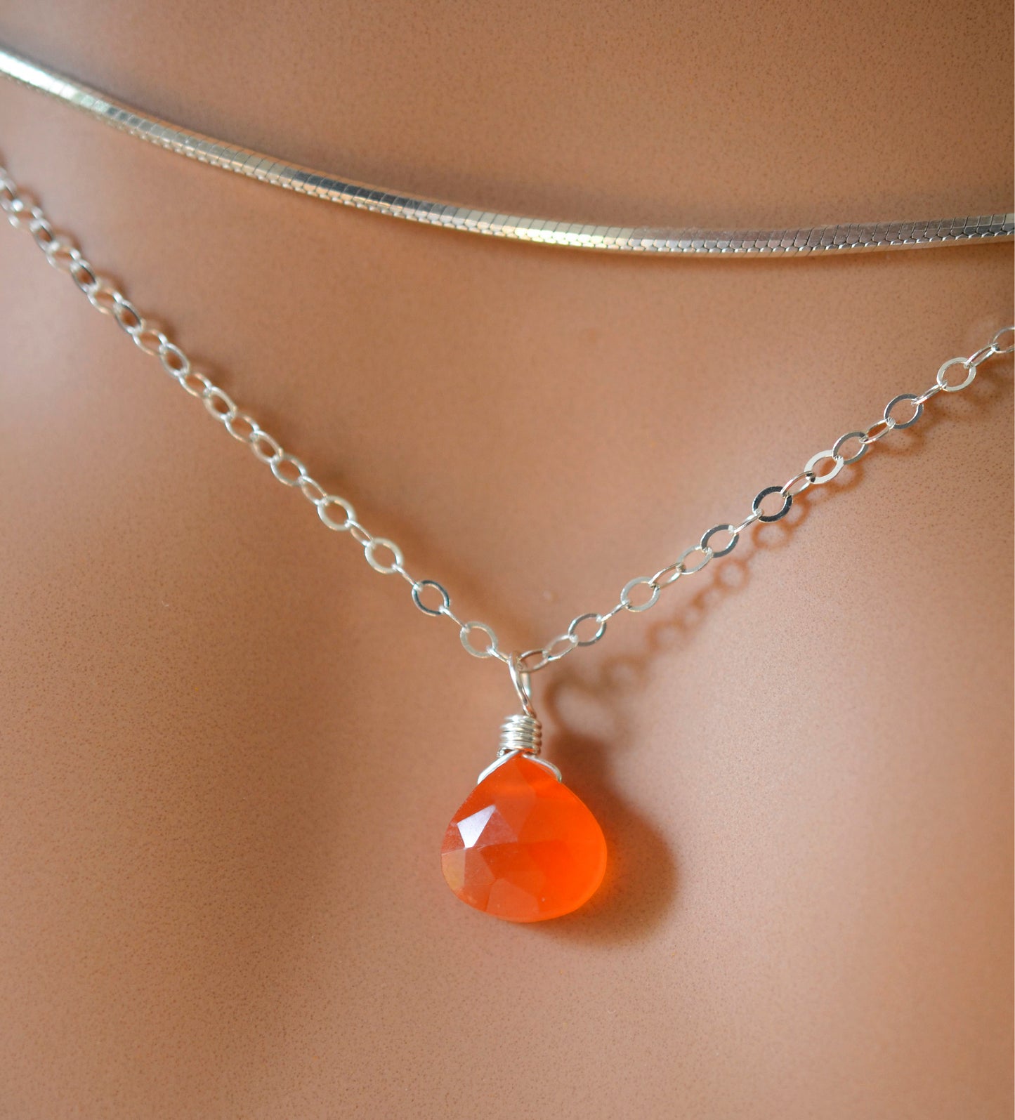 A sterling silver necklace handmade with natural, genuine, orange Carnelian crystal. This necklace is modeled with a chain choker and is also available in a dainty 14k gold filled chain.