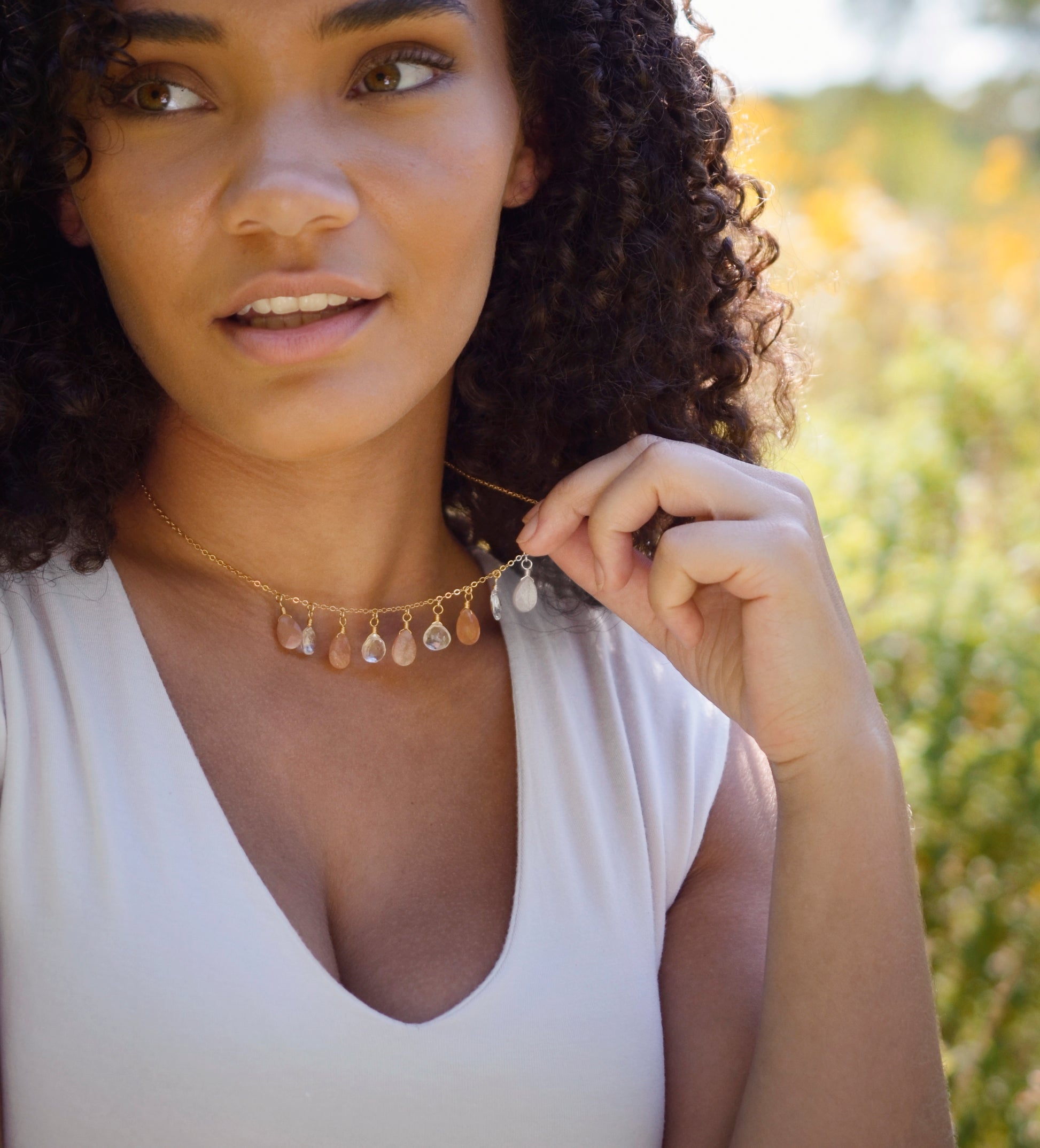 Orange, peach Sunstone and clear Crystal Quartz teardrops dangle off a 14k gold filled chain.  Modeled image.