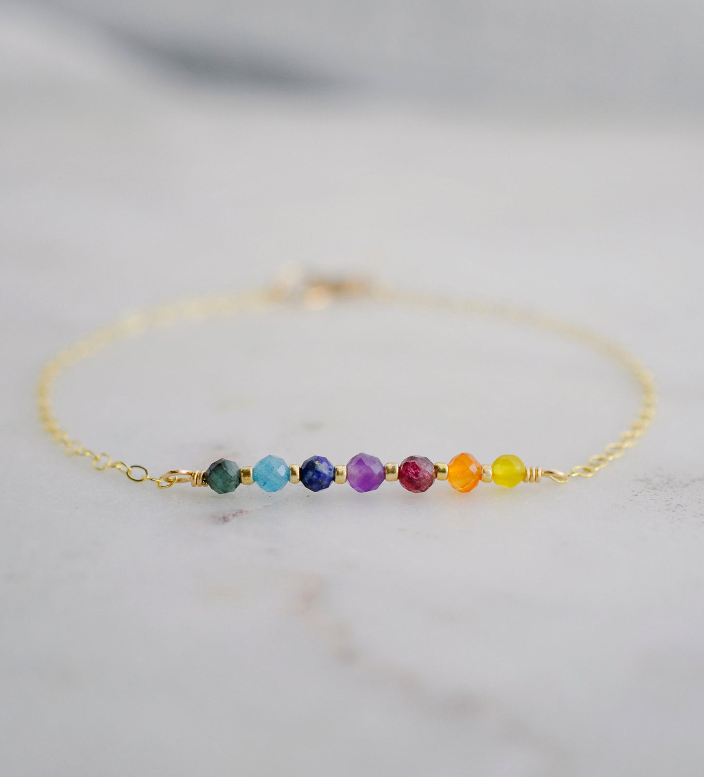 A minimalist chakra bracelet handmade with tiny natural crystals in the order of the rainbow. The chain is 14k gold filled or sterling silver. 