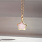 Dainty rose quartz star pendant necklace on a gold chain.