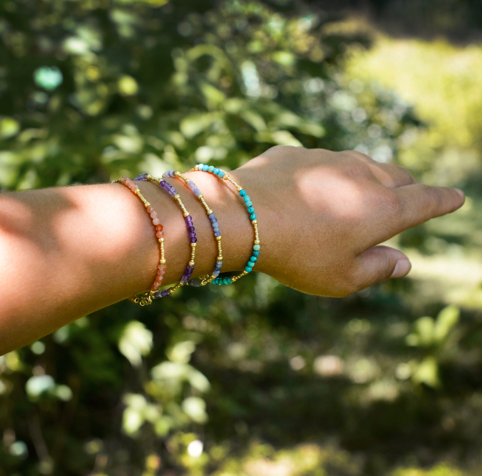 Handmade beaded gemstone crystal bracelet in gold filled or sterling silver. These bracelets feature a gemstone of your choice on a bracelet that can be stacked with others or worn alone. Modeled image showing: turquoise, tanzanite, amethyst, and sunstone.