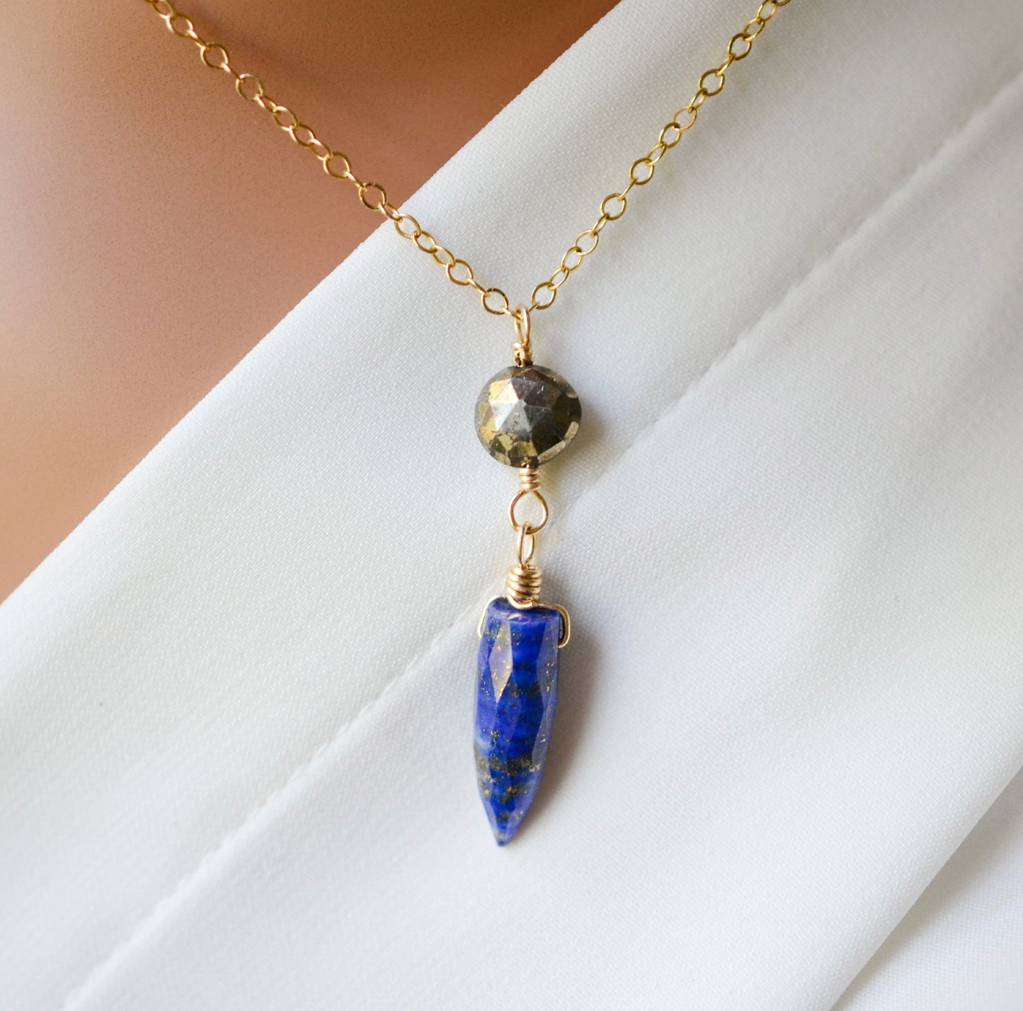 Close up image. This necklace is handmade with natural pyrite and lapis lazuli suspended from a 14k gold filled or sterling silver chain.