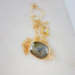A gold Labradorite necklace. The handmade pendant pendant is bezeled in gold and set on a 14k gold filled chain. This necklace is also available in sterling silver. The stone is oval in shape and flashes blue, green, or yellow.
