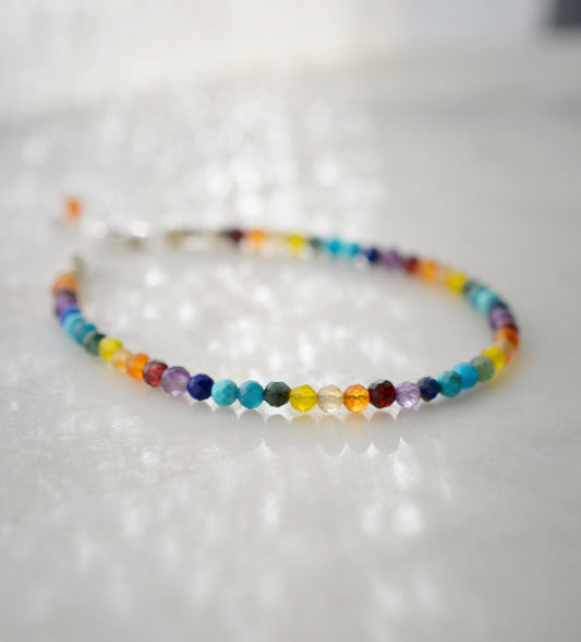 Tiny gemstone beaded bracelet in rainbow colors. Colors include: blue, green, yellow, red, orange, and purple. This bracelet is handmade in Connecticut by Gemnia Jewelry.