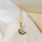 A gold-filled chain necklace with a faceted crescent moon-shaped labradorite gemstone pendant. Handmade in Connecticut.