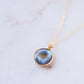 A handmade blue and green flash labradorite stone pendant in a smooth polished doughnut shape set on a 14k gold filled chain. Handcrafted artisan jewelry from Connecticut by Gemnia.