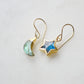 Labradorite Moon and Star earrings. One dangle is a faceted crescent moon, while the other is a star. The stones are naturally gray in color, but shift blue or green with movement. Available in gold or silver.