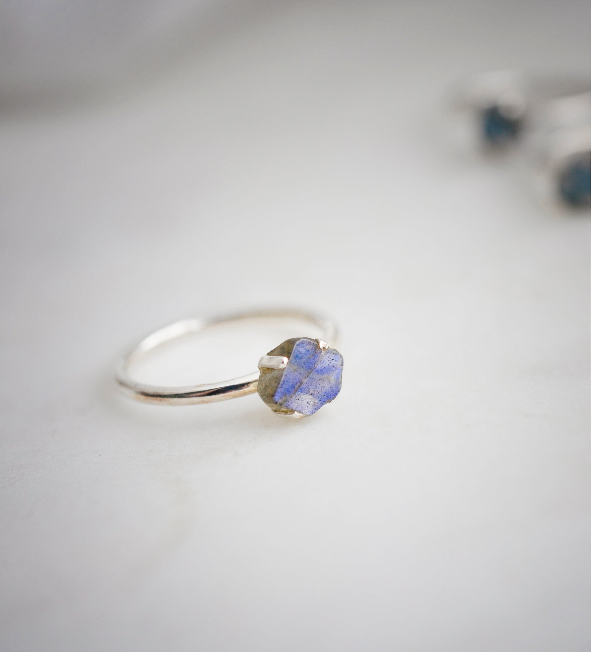 Labradorite gemstone set on a sterling silver ring with a purple-blue flash.
