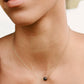Handmade genuine black lava round stone placed onto a 14k gold filled chain. Modeled image.