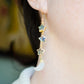 These earrings are handmade with natural labradorite gemstone stars and rainbow moonstone crescent moons. Shown in gold, these dangles are long, but light weight. Modeled image.