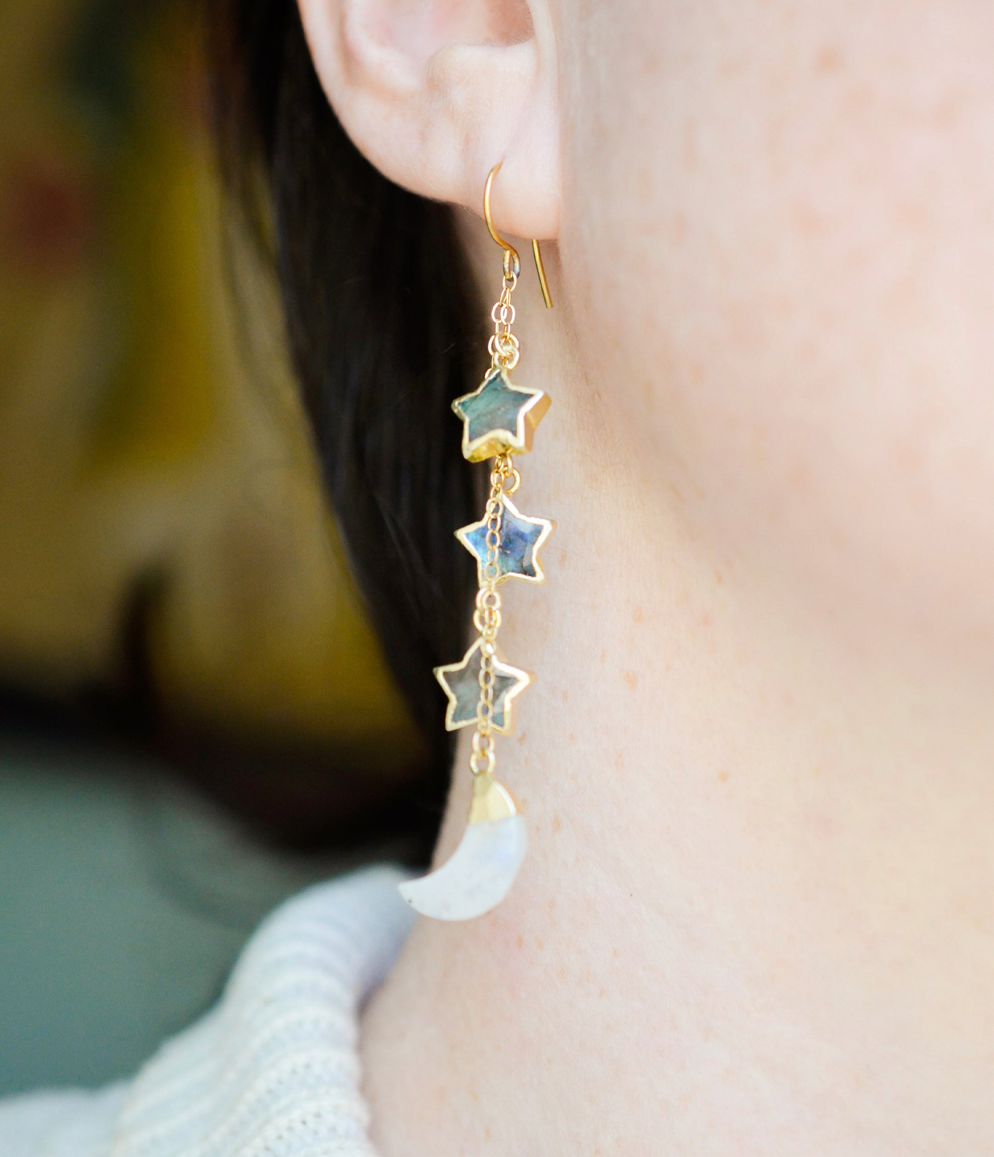 These earrings are handmade with natural labradorite gemstone stars and rainbow moonstone crescent moons. Shown in gold, these dangles are long, but light weight. Modeled image.