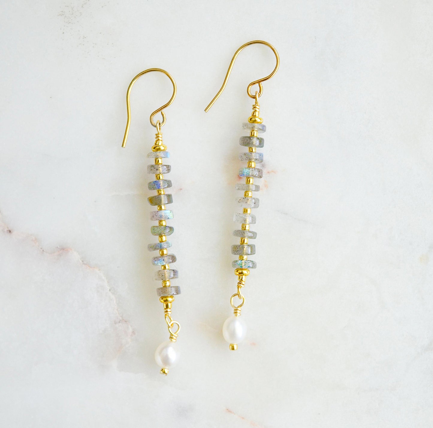 Handmade beaded dangle earrings with labradorite and white freshwater pearls. These artisan earrings are a long bar style with dainty pearls on the bottom. The gemstones flash blue and green.