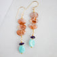 Three sunstone gemstone dangle atop amethyst and amazonite stones. The earring are shown in gold. 