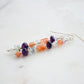 Mismatched gemstone long bar earrings shown in sterling silver. Stones include: amethyst, aquamarine, fluorite, and sunstone. Stones are set onto a long straight bar.