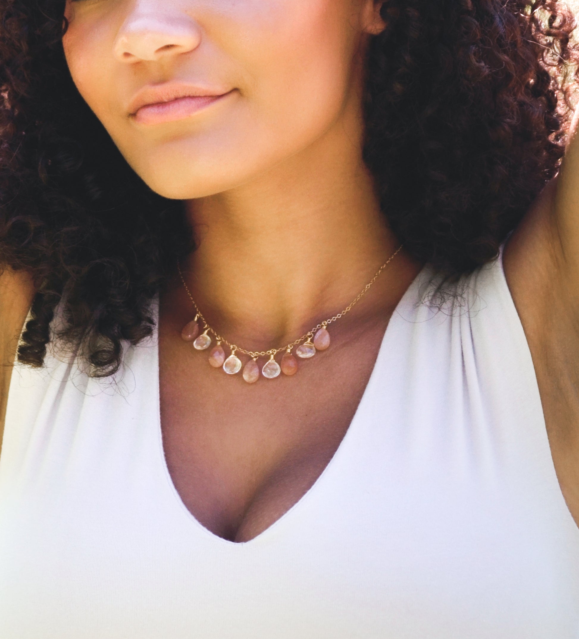 Orange, peach Sunstone and clear Crystal Quartz teardrops dangle off a 14k gold filled chain. Modeled image. 