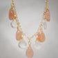 Orange, peach Sunstone and clear Crystal Quartz teardrops dangle off a 14k gold filled chain. 