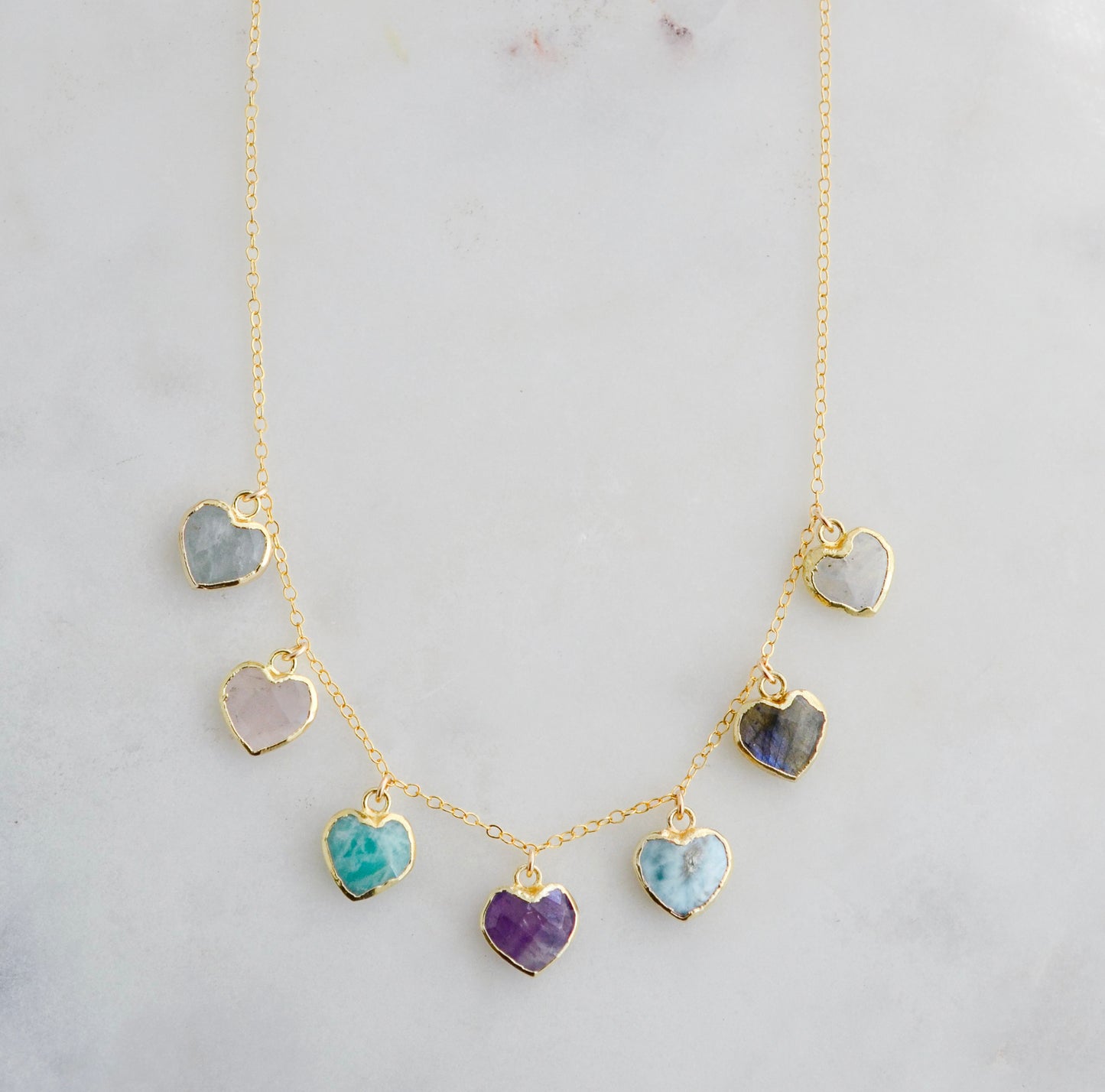 Handmade dainty heart necklace with heart-shaped gemstones on a 14k gold filed chain. Stones include: Aquamarine, Rose Quartz, Amazonite, Larimar, Labradorite, Amethyst, and Rainbow Moonstone