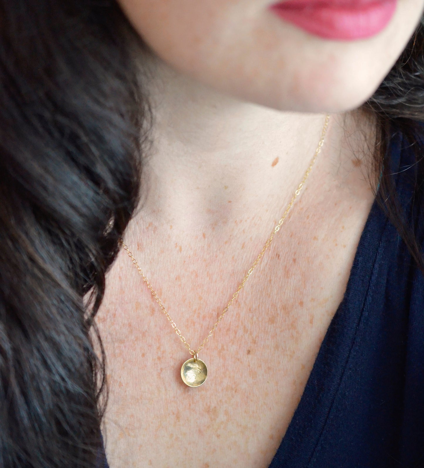 The Aum / Om symbol stamped into a circle disc and put on a gold filled chain. Modeled image.