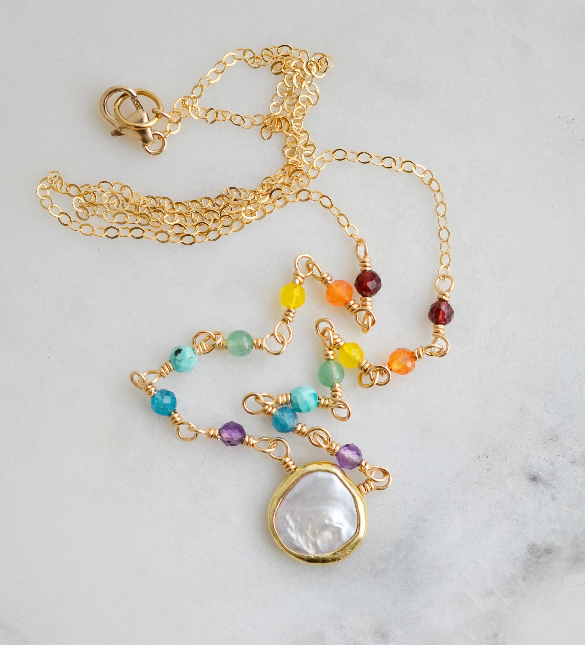 Rainbow, pride, or chakra necklace with tiny gemstones and a white freshwater pearl. The 14k gold filled style is shown.