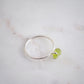 Rough green peridot ring on a sterling silver band. Close up image.