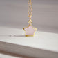 Dainty rose quartz star pendant necklace on a gold chain.
