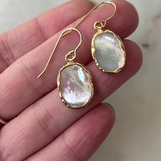 Movie showcasing the flashing white and silver shades of the mother of pearl dangle earrings.