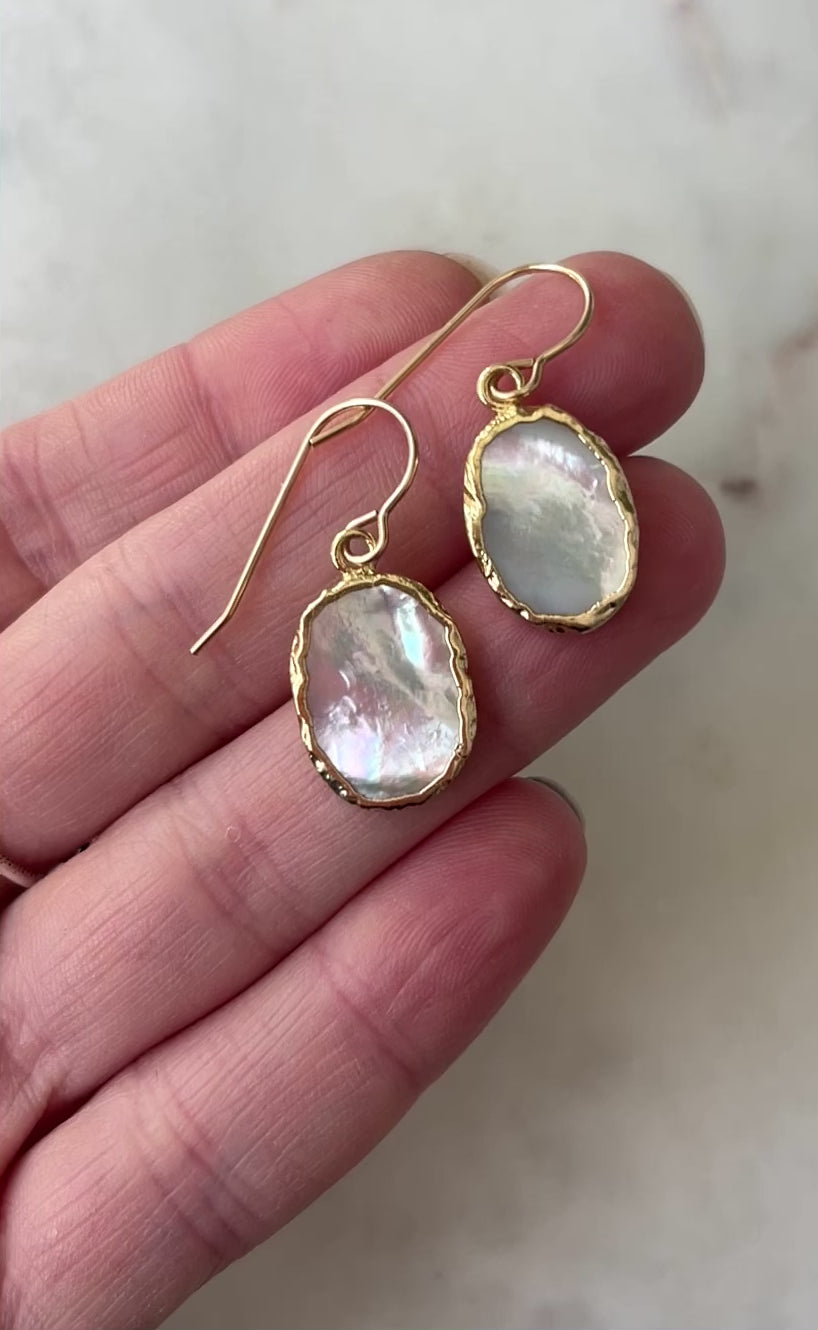 Movie showcasing the flashing white and silver shades of the mother of pearl dangle earrings.