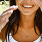 Woman wearing a necklace with a star pendant, outdoors. Modeled in sterling silver.
