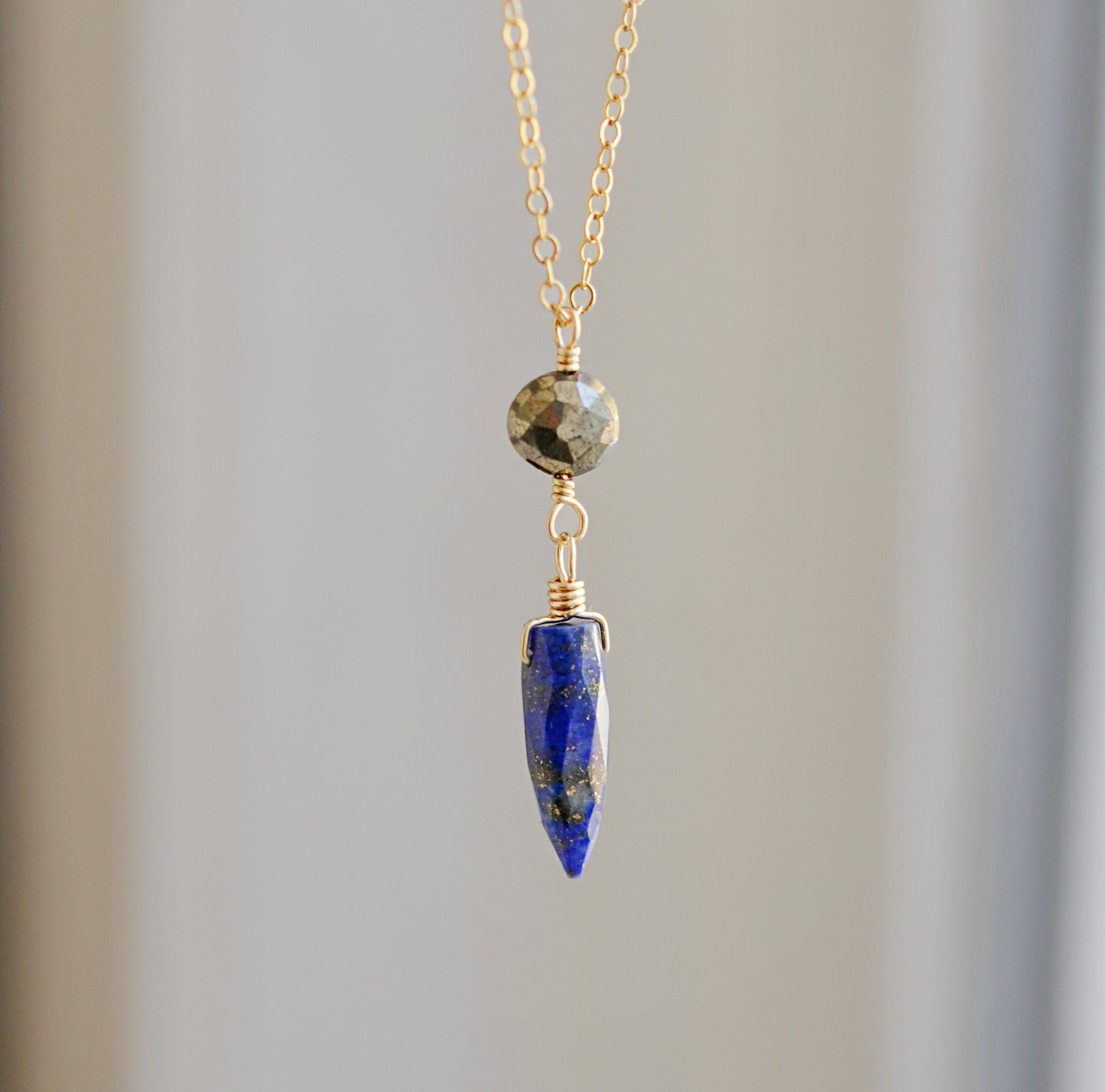 This necklace is handmade with natural pyrite and lapis lazuli suspended from a 14k gold filled or sterling silver chain.