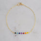 A dainty, minimalist chakra pride beaded chain bracelet handmade with small natural gemstones in rainbow colors. 
