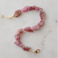 Raw pink tourmaline bracelet with tiny gold beads in-between each stone. The adjustable style is shown.