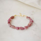 Raw pink tourmaline bracelet with tiny gold beads in-between each stone. The adjustable style is shown.