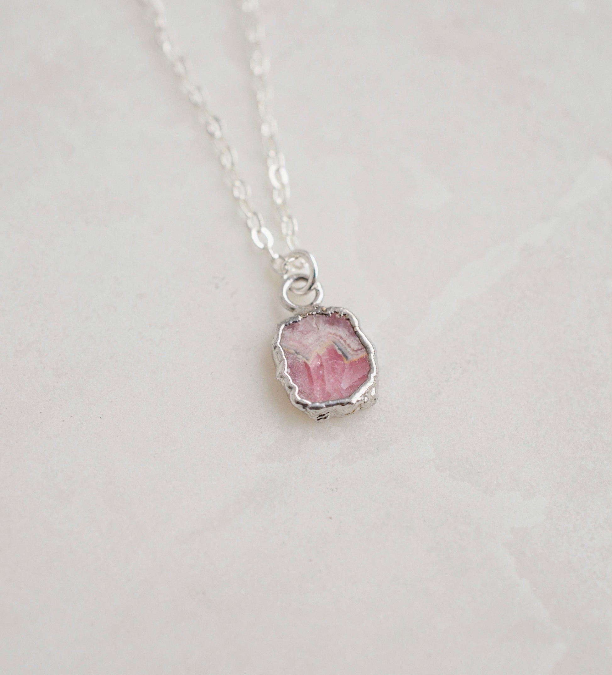 Natural pink Rhodochrosite sliced gemstone bezeled in sterling silver and set on a sterling chain.