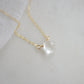 A clear, natural crystal quartz faceted teardrop set onto a 14k gold filled chain.